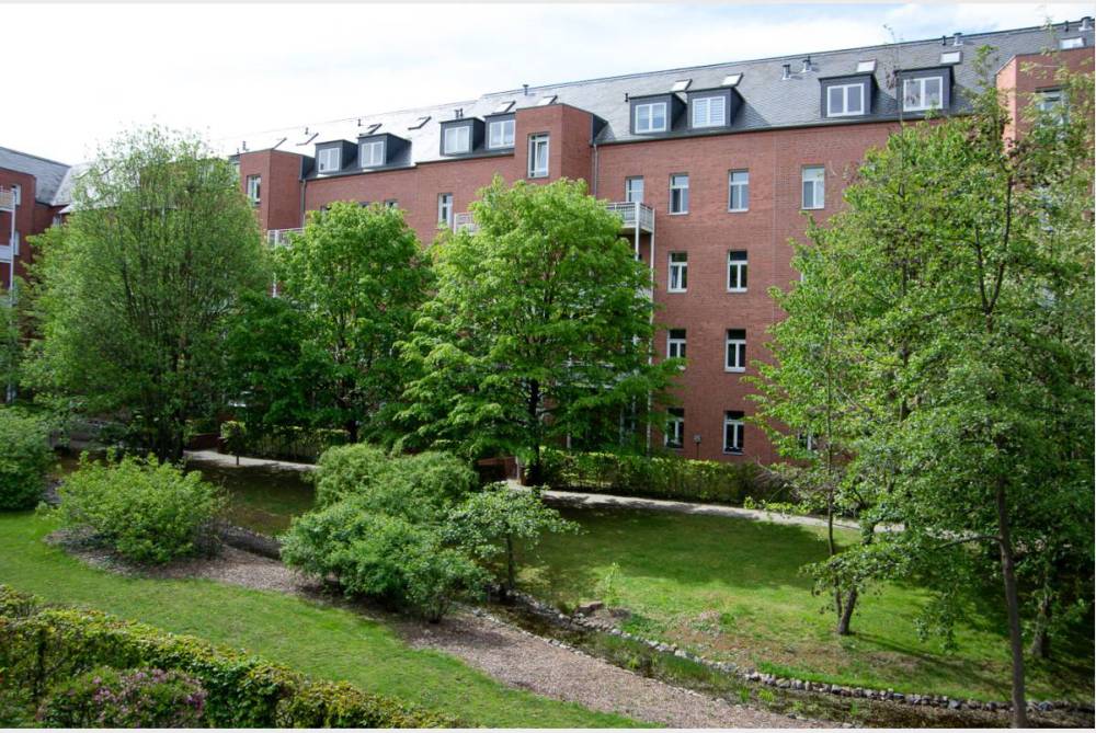 grüner Innenhof mit Bachlauf